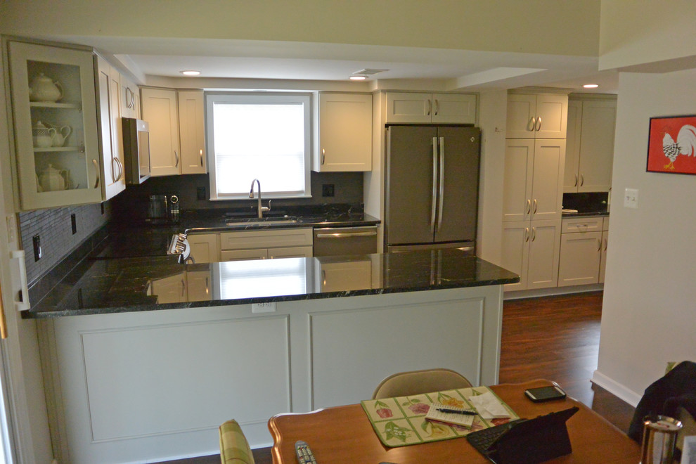 Example of a small transitional u-shaped medium tone wood floor and brown floor eat-in kitchen design in Baltimore with an undermount sink, shaker cabinets, gray cabinets, granite countertops, gray backsplash, mosaic tile backsplash, stainless steel appliances, a peninsula and gray countertops