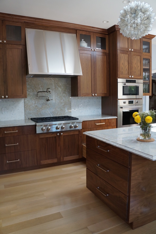 This is an example of a large modern l-shaped kitchen pantry in Boston with a single-bowl sink, flat-panel cabinets, brown cabinets, composite countertops, grey splashback, mosaic tiled splashback, stainless steel appliances, light hardwood flooring and an island.