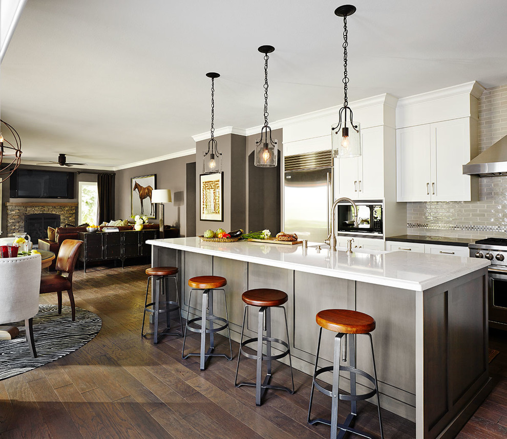 Eat-in kitchen - large transitional l-shaped dark wood floor eat-in kitchen idea in San Francisco with a farmhouse sink, shaker cabinets, white cabinets, beige backsplash, stainless steel appliances, an island, quartz countertops and subway tile backsplash