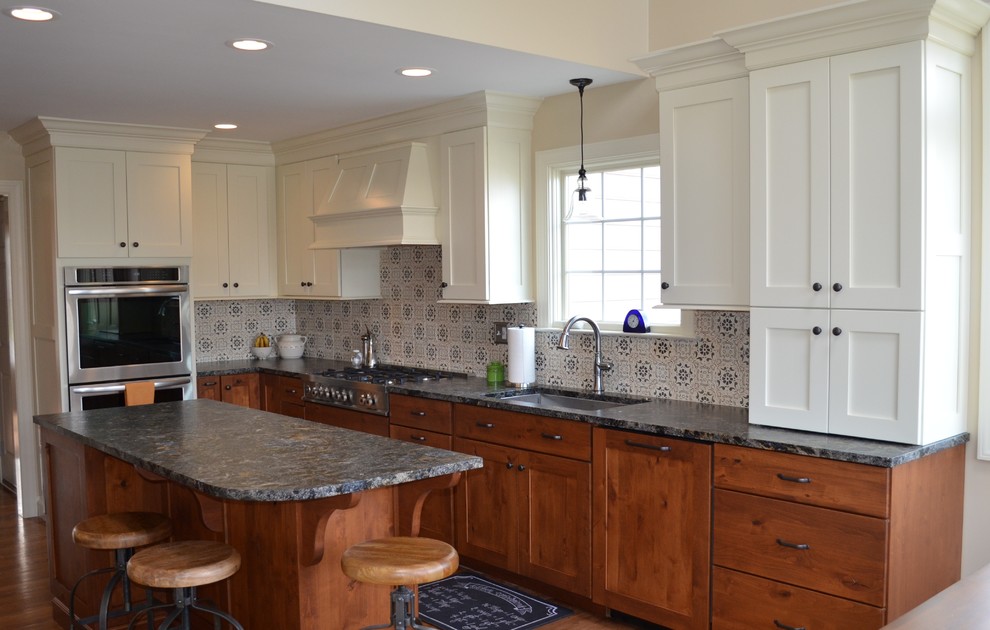 Eat-in kitchen - traditional l-shaped eat-in kitchen idea in Other with an undermount sink, recessed-panel cabinets, granite countertops, white backsplash, terra-cotta backsplash and stainless steel appliances