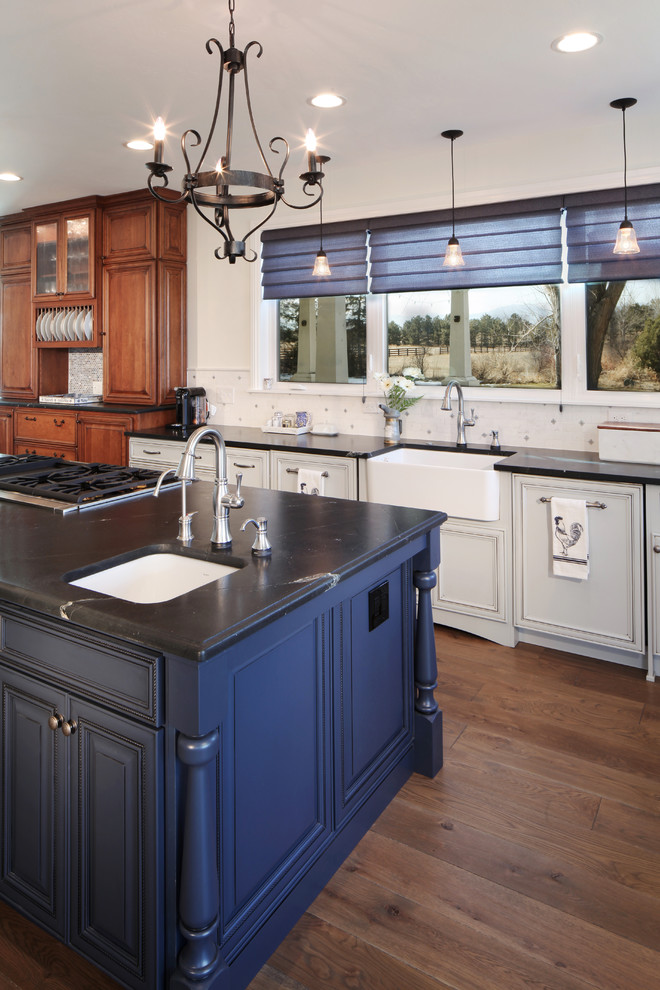 Große Klassische Küche mit Schrankfronten mit vertiefter Füllung, blauen Schränken, Granit-Arbeitsplatte, Küchenrückwand in Weiß, Rückwand aus Keramikfliesen, Küchengeräten aus Edelstahl, braunem Holzboden und Kücheninsel in Denver