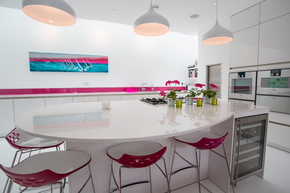 Foto på ett stort funkis kök, med släta luckor, vita skåp, bänkskiva i koppar, rosa stänkskydd, glaspanel som stänkskydd, rostfria vitvaror och en köksö