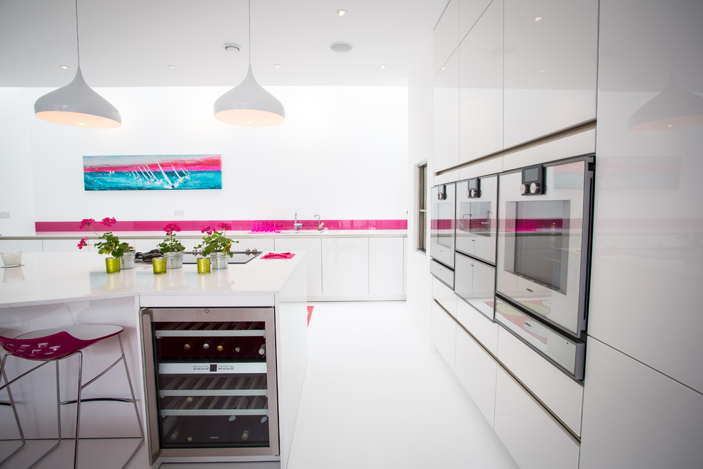 Exempel på ett stort modernt kök, med en undermonterad diskho, släta luckor, vita skåp, bänkskiva i koppar, rosa stänkskydd, glaspanel som stänkskydd, rostfria vitvaror och en köksö