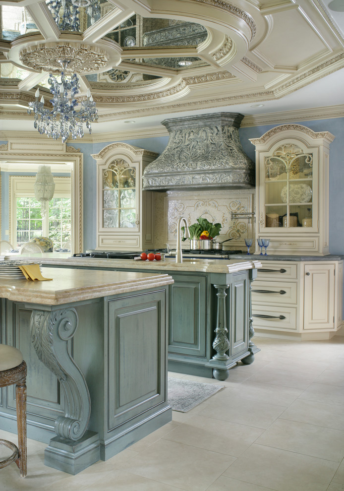 Exempel på ett stort klassiskt kök, med en rustik diskho, luckor med profilerade fronter, beige skåp, bänkskiva i kalksten, beige stänkskydd, stänkskydd i mosaik, svarta vitvaror, kalkstensgolv och flera köksöar