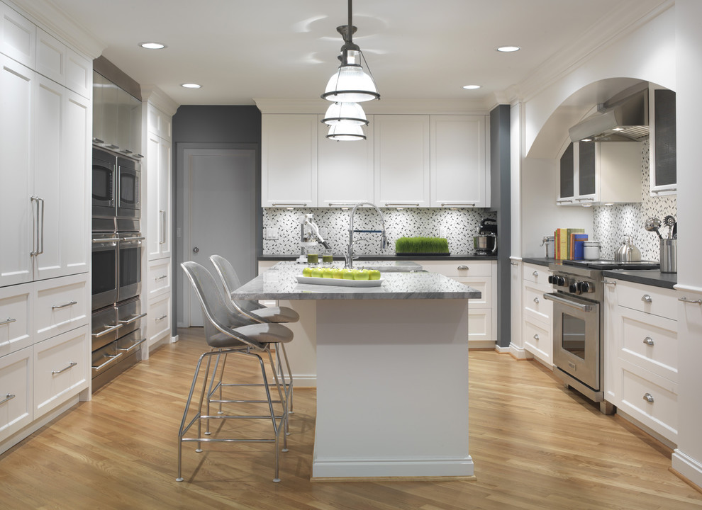 Bild på ett funkis kök och matrum, med rostfria vitvaror, en rustik diskho, skåp i shakerstil, vita skåp, bänkskiva i kvarts, ljust trägolv och en köksö