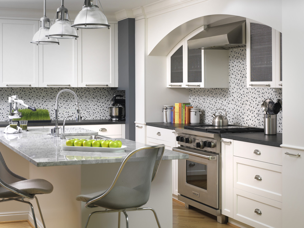 Moderne Wohnküche mit Küchengeräten aus Edelstahl, Landhausspüle, Schrankfronten im Shaker-Stil, weißen Schränken, Quarzwerkstein-Arbeitsplatte, hellem Holzboden und Kücheninsel in Detroit