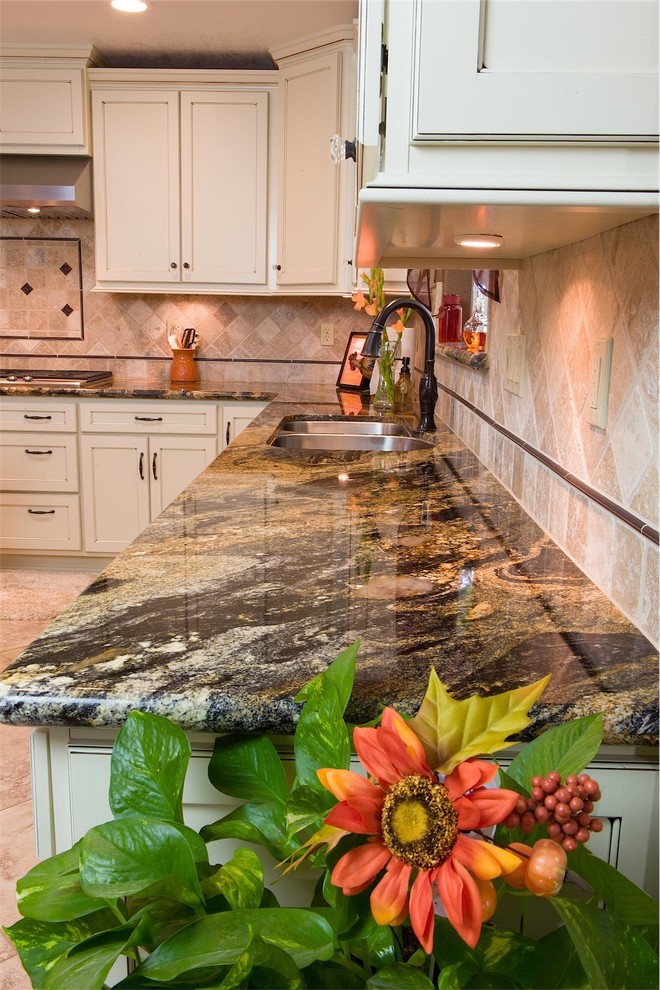 Example of a mid-sized classic u-shaped porcelain tile open concept kitchen design in Other with an undermount sink, recessed-panel cabinets, white cabinets, granite countertops, beige backsplash, stainless steel appliances and stone tile backsplash