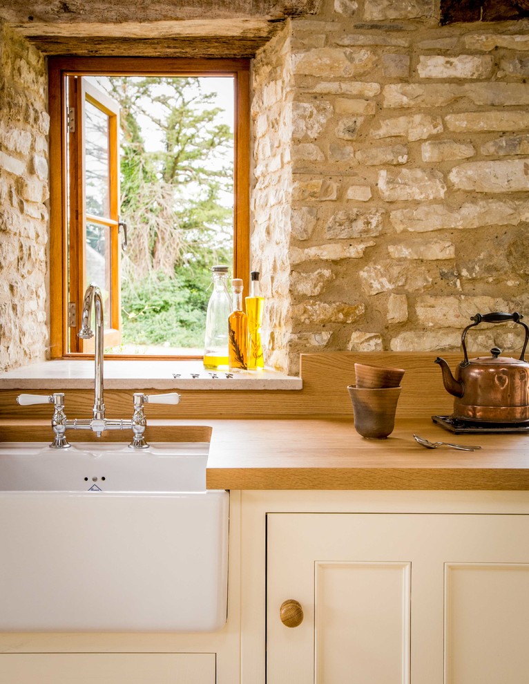 Open concept kitchen - large traditional u-shaped ceramic tile open concept kitchen idea in Other with a farmhouse sink, white cabinets, wood countertops, an island, beaded inset cabinets and stainless steel appliances