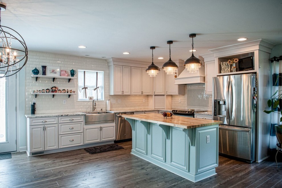 Example of a large transitional l-shaped dark wood floor eat-in kitchen design in Charlotte with a farmhouse sink, raised-panel cabinets, white cabinets, granite countertops, white backsplash, stainless steel appliances, an island and subway tile backsplash