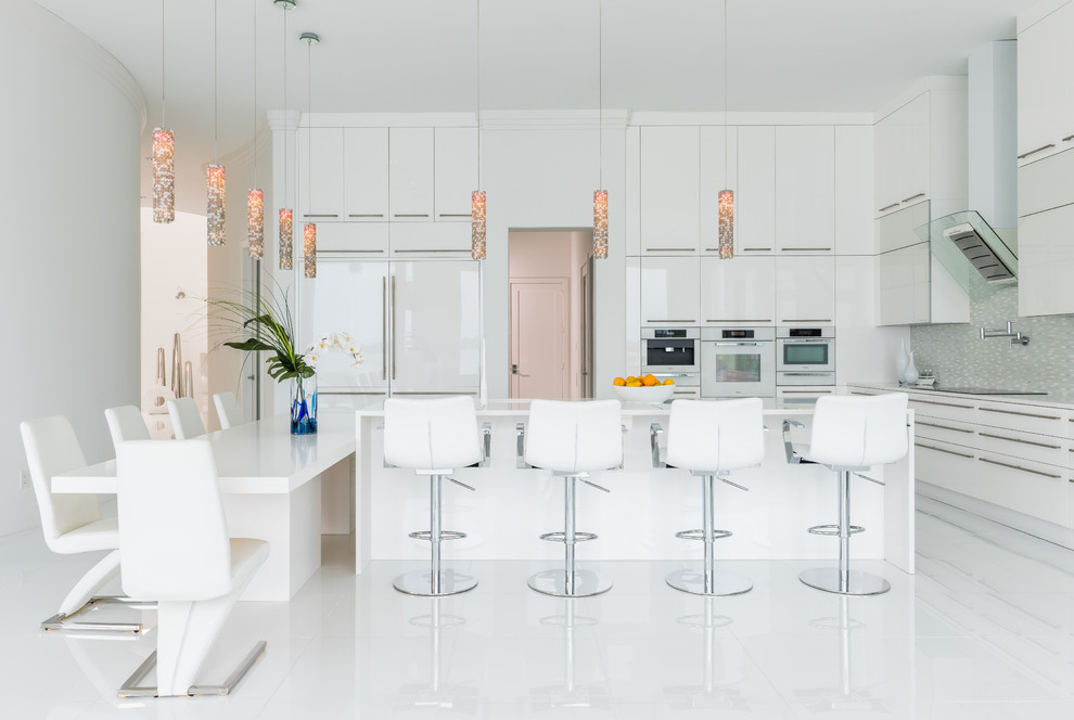 Свежая идея для дизайна: угловая кухня в современном стиле с плоскими фасадами, белыми фасадами, фартуком из плитки мозаики, белой техникой и островом - отличное фото интерьера