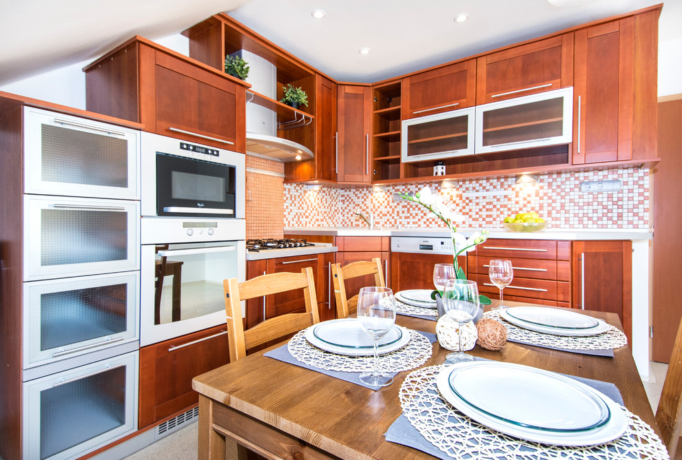 Inredning av ett eklektiskt litet kök, med en enkel diskho, luckor med infälld panel, skåp i mellenmörkt trä, laminatbänkskiva, orange stänkskydd, stänkskydd i mosaik, rostfria vitvaror och linoleumgolv