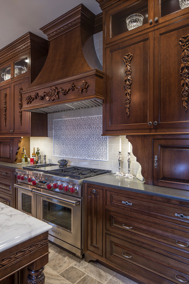 ボルチモアにあるトラディショナルスタイルのおしゃれなアイランドキッチン (落し込みパネル扉のキャビネット、濃色木目調キャビネット、グレーのキッチンパネル、シルバーの調理設備) の写真