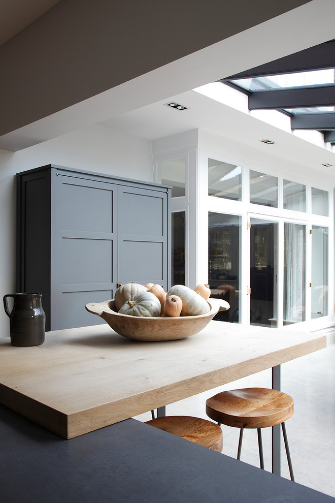 サリーにあるインダストリアルスタイルのおしゃれなキッチン (グレーのキャビネット、木材カウンター、コンクリートの床、グレーの床) の写真