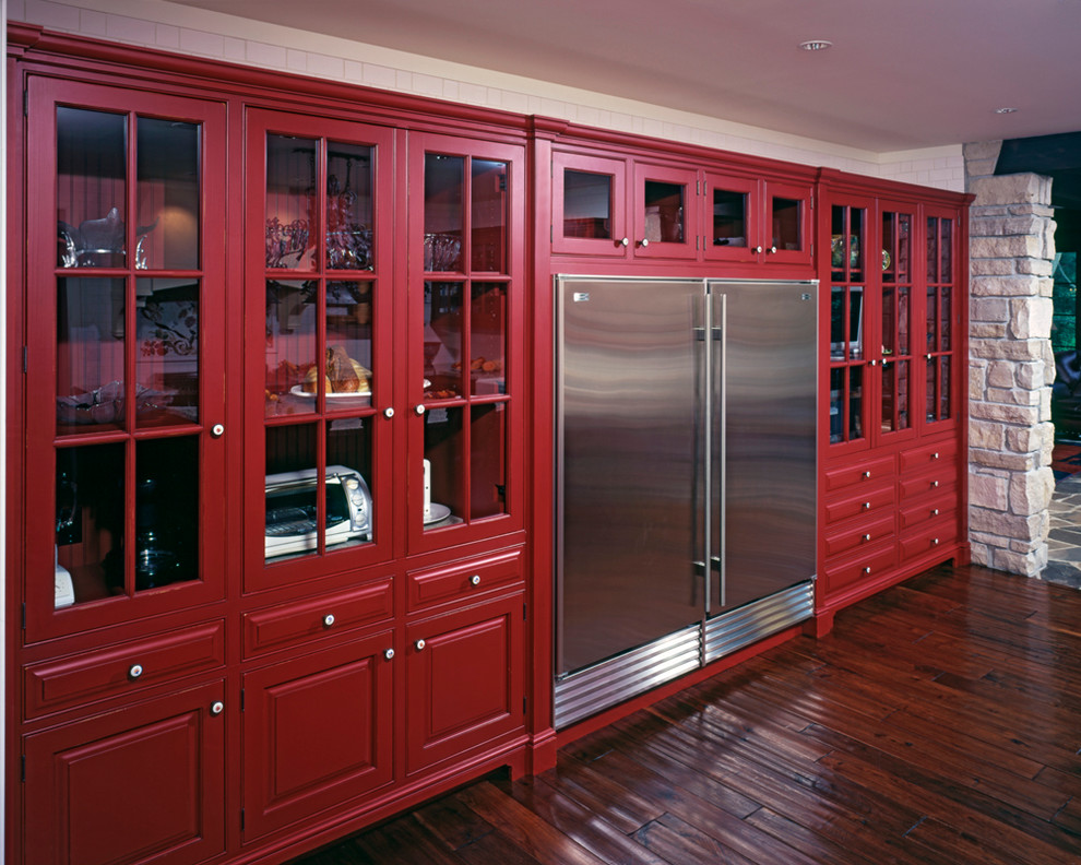 Klassische Wohnküche in U-Form mit profilierten Schrankfronten, roten Schränken, Granit-Arbeitsplatte, Küchenrückwand in Weiß, Rückwand aus Keramikfliesen, dunklem Holzboden und Kücheninsel in Sonstige