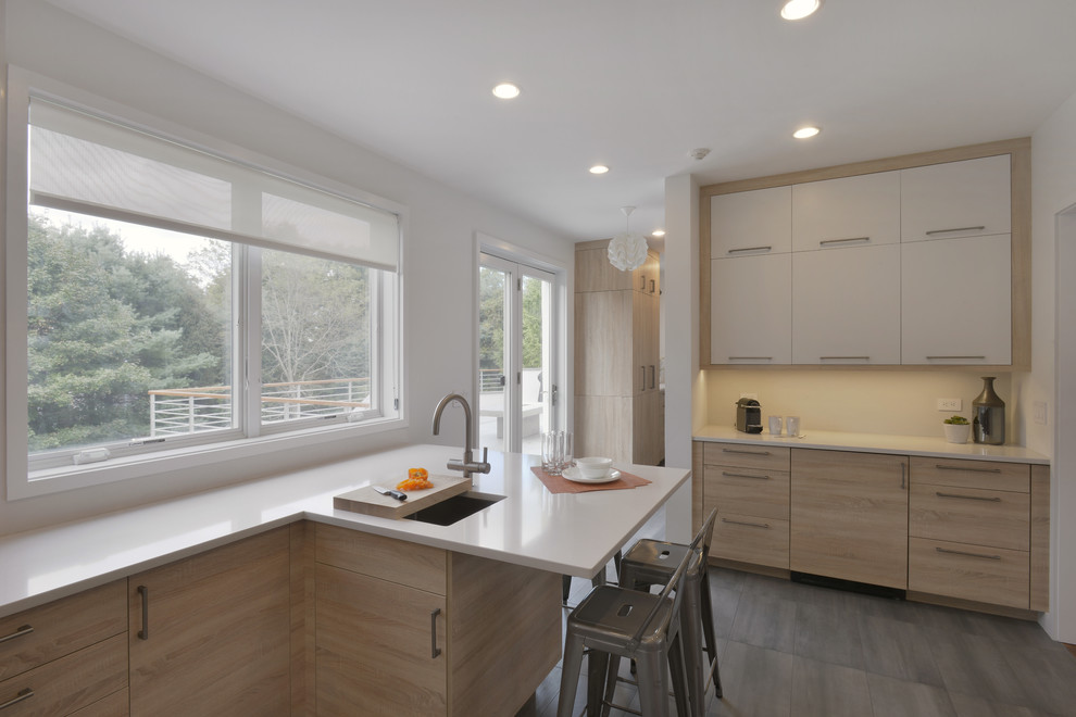 Example of a mid-sized minimalist u-shaped porcelain tile and gray floor enclosed kitchen design in New York with an undermount sink, flat-panel cabinets, light wood cabinets, quartzite countertops, white backsplash, porcelain backsplash and stainless steel appliances