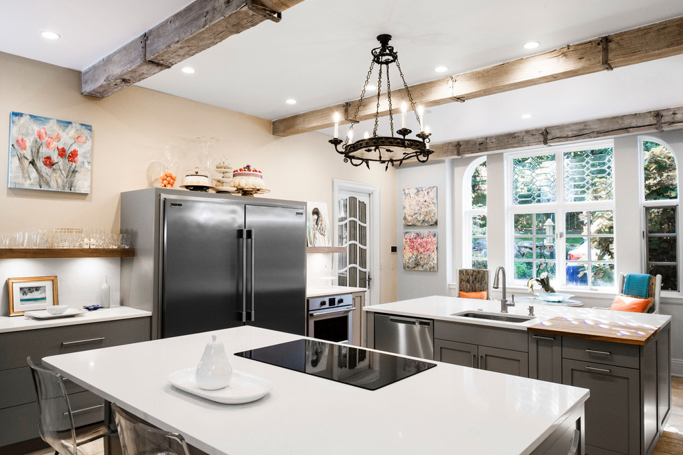Mid-sized transitional ceramic tile and brown floor enclosed kitchen photo in Other with an undermount sink, flat-panel cabinets, beige cabinets, quartzite countertops, white backsplash, ceramic backsplash, stainless steel appliances, two islands and white countertops
