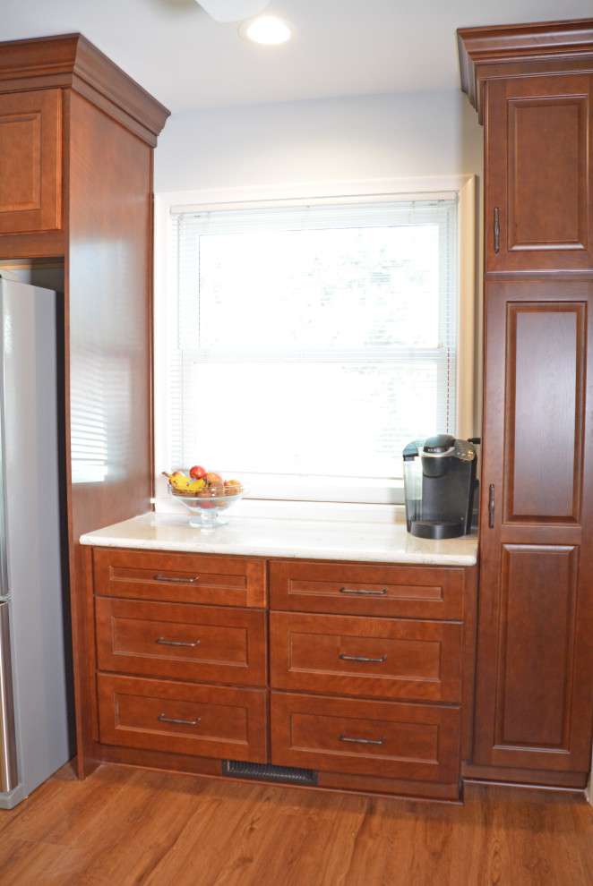 Exempel på ett avskilt, litet klassiskt vit vitt u-kök, med en dubbel diskho, luckor med upphöjd panel, skåp i mellenmörkt trä, bänkskiva i kvarts, flerfärgad stänkskydd, stänkskydd i glaskakel, rostfria vitvaror, vinylgolv och brunt golv