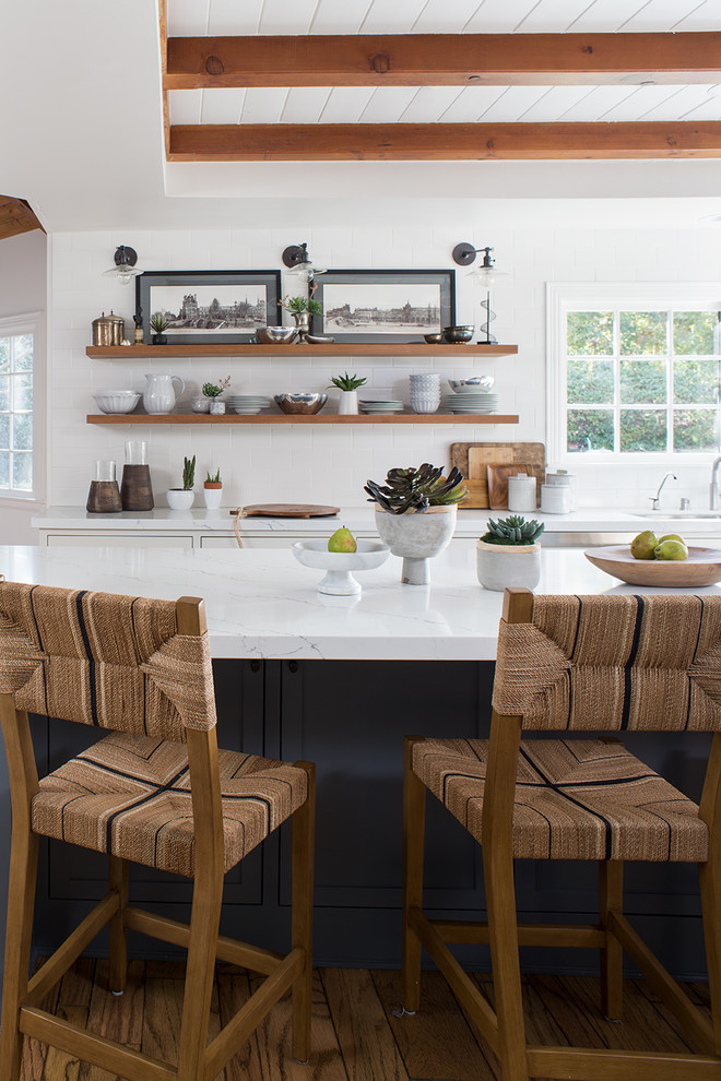 Large transitional l-shaped light wood floor and brown floor open concept kitchen photo in Los Angeles with an undermount sink, shaker cabinets, quartz countertops, stainless steel appliances, an island, white cabinets, white backsplash, white countertops and subway tile backsplash