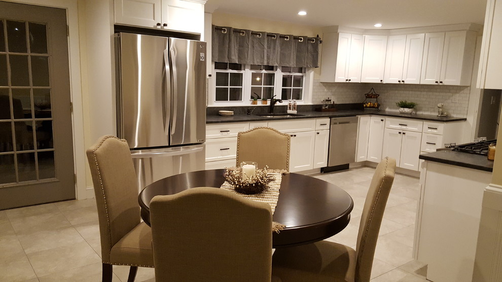 Example of a mid-sized farmhouse galley porcelain tile and beige floor enclosed kitchen design in Boston with an undermount sink, shaker cabinets, white cabinets, granite countertops, white backsplash, stainless steel appliances, subway tile backsplash and no island