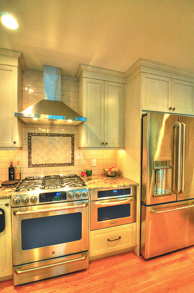 Exempel på ett mellanstort klassiskt kök, med en enkel diskho, skåp i shakerstil, beige skåp, laminatbänkskiva, grått stänkskydd, stänkskydd i tunnelbanekakel, rostfria vitvaror och ljust trägolv