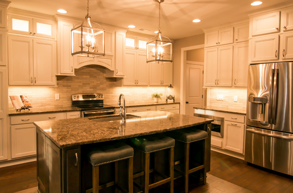 Exempel på ett stort klassiskt kök, med en undermonterad diskho, luckor med infälld panel, vita skåp, granitbänkskiva, beige stänkskydd, stänkskydd i stickkakel, rostfria vitvaror, mörkt trägolv och en köksö