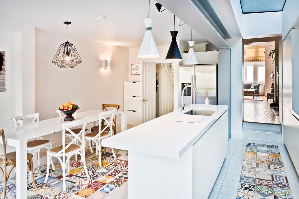 This is an example of a contemporary kitchen/diner in London with a submerged sink, stainless steel appliances and an island.