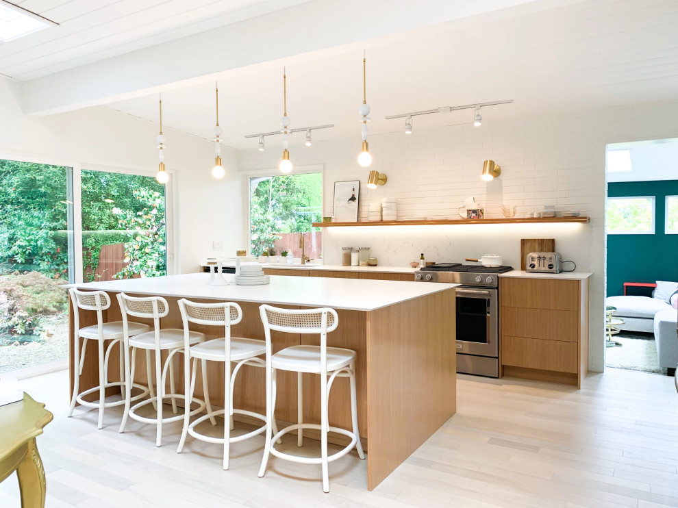 Foto di un cucina con isola centrale minimalista con ante lisce, ante in legno chiaro e pavimento grigio