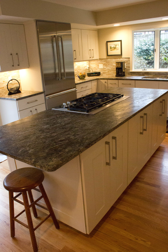 Example of a large trendy l-shaped light wood floor eat-in kitchen design in Detroit with an undermount sink, recessed-panel cabinets, white cabinets, granite countertops, multicolored backsplash, stainless steel appliances and an island