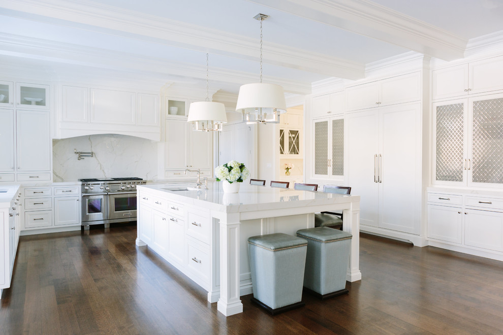 Inspiration for a transitional u-shaped dark wood floor and brown floor open concept kitchen remodel in Chicago with beaded inset cabinets, white cabinets, tile countertops, white backsplash, porcelain backsplash, stainless steel appliances, an island, white countertops and an undermount sink