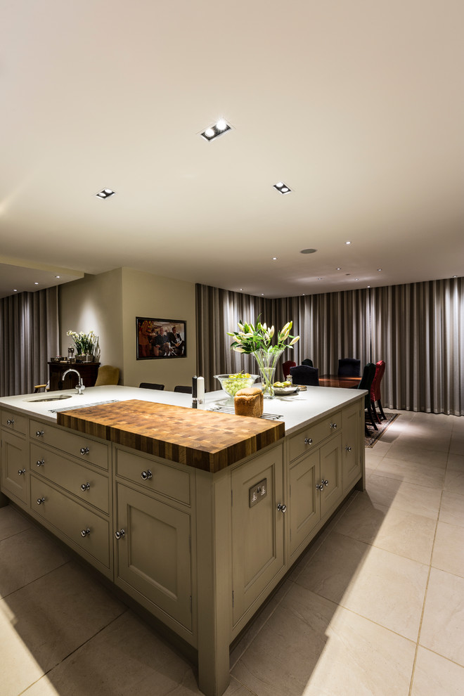 Large classic l-shaped open plan kitchen in Surrey with a submerged sink, shaker cabinets, green cabinets, marble worktops, black appliances, ceramic flooring and an island.
