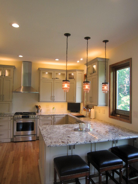 Example of a mid-sized trendy u-shaped light wood floor eat-in kitchen design in Chicago with a double-bowl sink, white cabinets, quartz countertops, white backsplash, stainless steel appliances, no island and recessed-panel cabinets