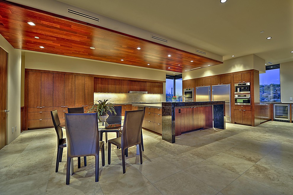 フェニックスにある巨大なコンテンポラリースタイルのおしゃれなキッチン (フラットパネル扉のキャビネット、中間色木目調キャビネット、ベージュキッチンパネル、シルバーの調理設備、御影石カウンター、ベージュの床) の写真