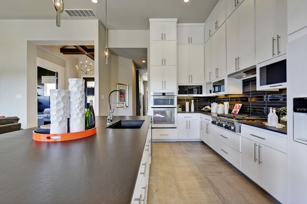 オースティンにあるトランジショナルスタイルのおしゃれなキッチン (シングルシンク、フラットパネル扉のキャビネット、白いキャビネット、黒いキッチンパネル、セラミックタイルのキッチンパネル) の写真