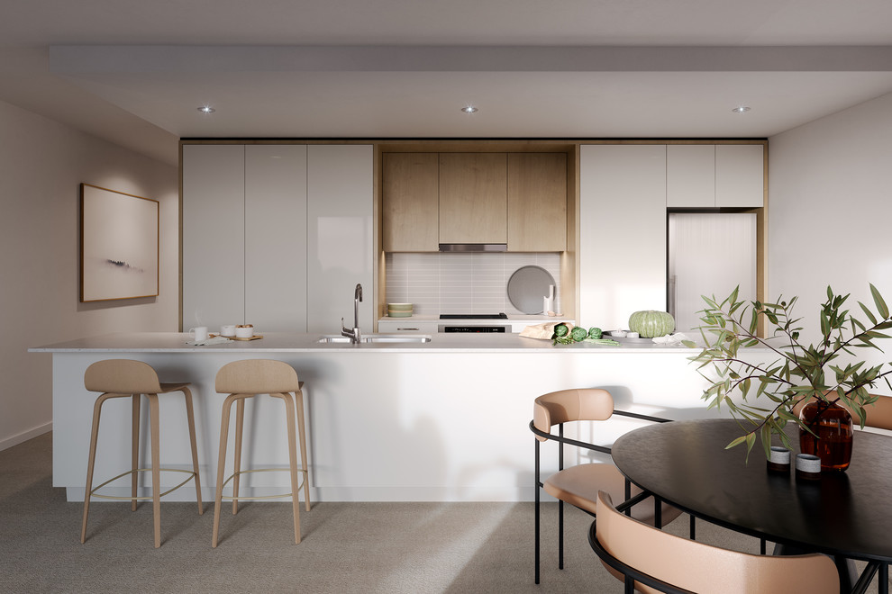 Photo of a large contemporary single-wall open plan kitchen in Other with an integrated sink, beaded cabinets, white cabinets, granite worktops, beige splashback, ceramic splashback, stainless steel appliances, ceramic flooring, an island, beige floors and white worktops.