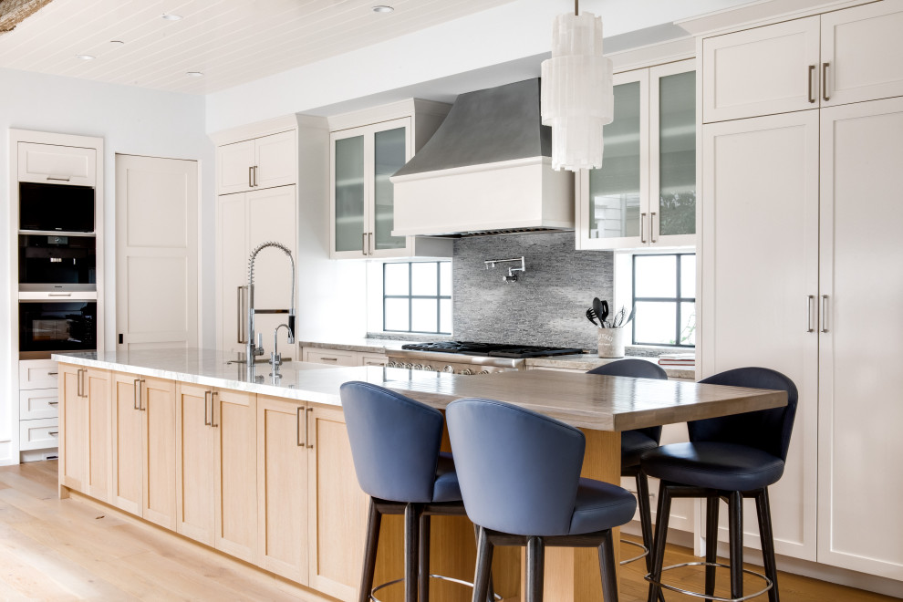 Foto di un cucina con isola centrale stile marinaro con paraspruzzi grigio, elettrodomestici in acciaio inossidabile, parquet chiaro, pavimento beige, top grigio, ante beige e ante in stile shaker