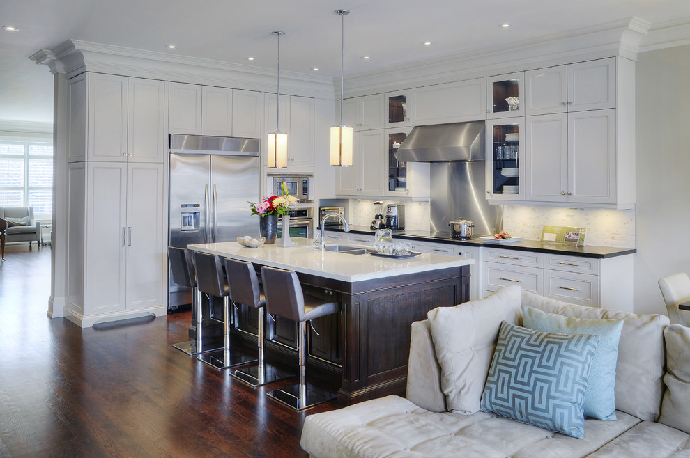 Inspiration for a large transitional l-shaped eat-in kitchen remodel in Toronto with an undermount sink, recessed-panel cabinets, white cabinets, quartz countertops, white backsplash and stainless steel appliances