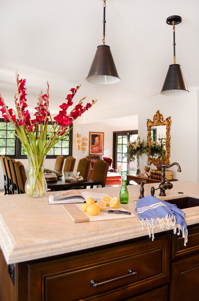 Large tuscan l-shaped dark wood floor and brown floor eat-in kitchen photo in Los Angeles with an undermount sink, raised-panel cabinets, brown cabinets, quartzite countertops, beige backsplash, stone slab backsplash, paneled appliances, an island and beige countertops