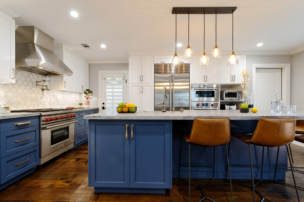 Klassisk inredning av ett litet blå blått kök, med en rustik diskho, skåp i shakerstil, blå skåp, vitt stänkskydd, stänkskydd i marmor, rostfria vitvaror, mellanmörkt trägolv och en köksö