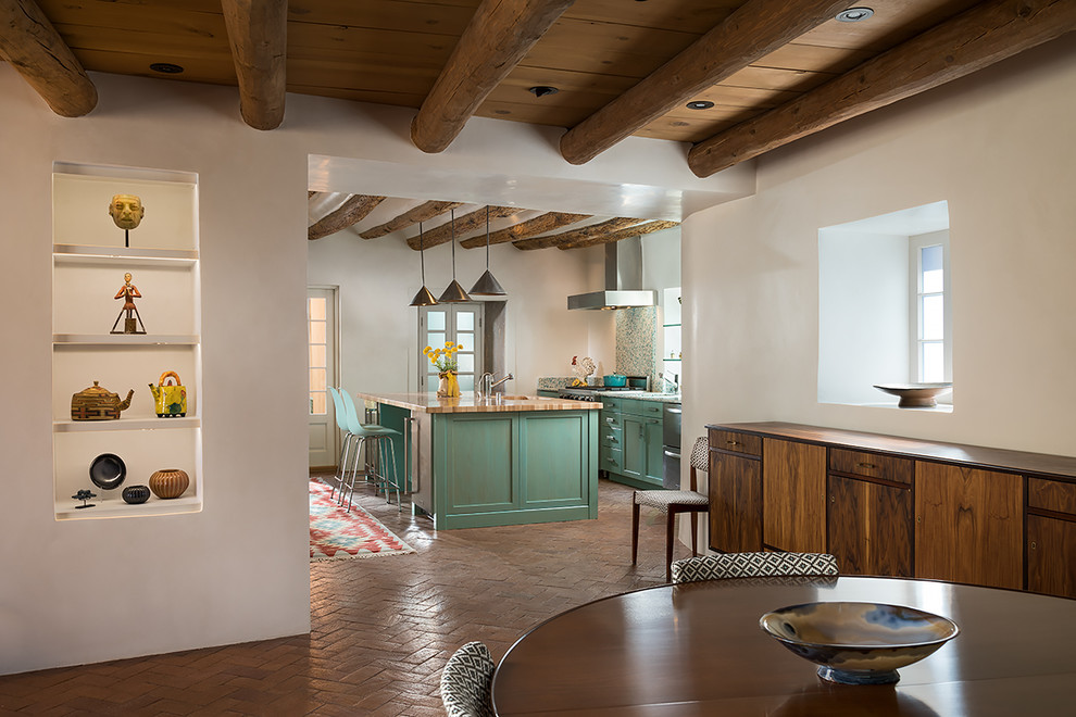 Mediterrane Wohnküche mit Schrankfronten im Shaker-Stil, grünen Schränken, Arbeitsplatte aus Holz, bunter Rückwand, Kücheninsel und braunem Boden in Albuquerque