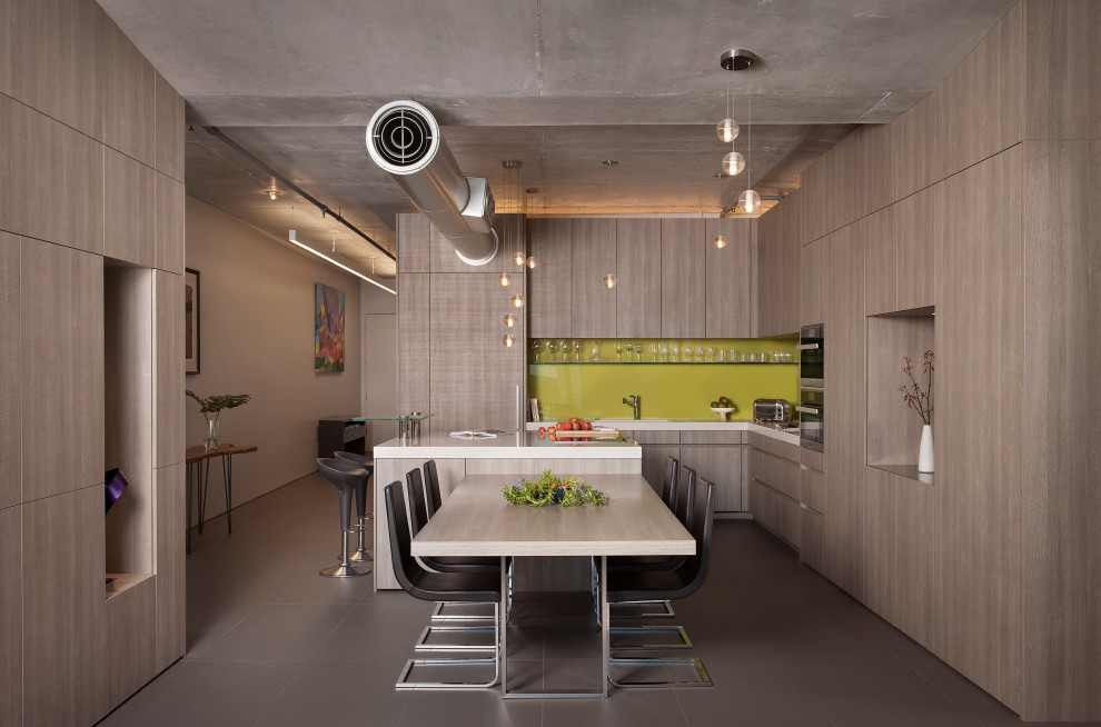 Idéer för funkis vitt l-kök, med en undermonterad diskho, släta luckor, grå skåp, grönt stänkskydd, integrerade vitvaror, en köksö och grått golv