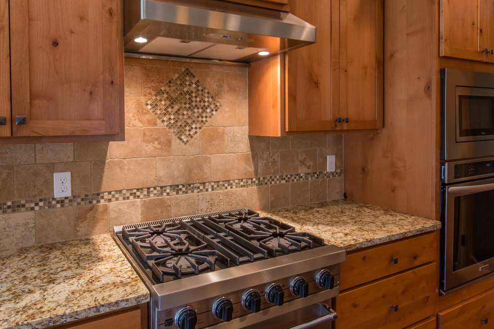 Bild på ett mellanstort amerikanskt kök, med en undermonterad diskho, skåp i shakerstil, skåp i mellenmörkt trä, granitbänkskiva, brunt stänkskydd, stänkskydd i keramik, rostfria vitvaror, mellanmörkt trägolv och en köksö