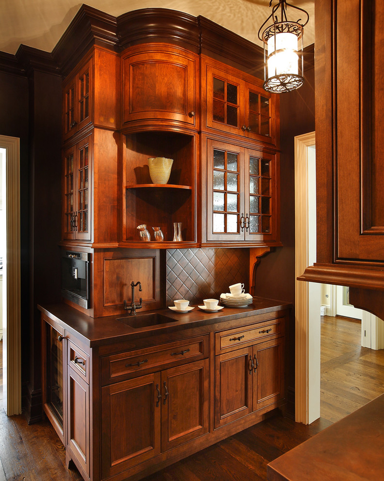 Ejemplo de cocina tradicional con armarios con rebordes decorativos, puertas de armario de madera en tonos medios, fregadero integrado y encimera de cobre