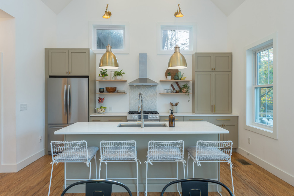Idéer för ett mellanstort klassiskt vit linjärt kök och matrum, med en undermonterad diskho, skåp i shakerstil, beige skåp, bänkskiva i kvarts, vitt stänkskydd, stänkskydd i keramik, rostfria vitvaror, bambugolv, en köksö och brunt golv