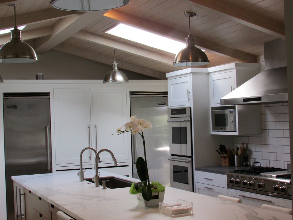 Idéer för att renovera ett avskilt, mellanstort lantligt vit vitt l-kök, med en undermonterad diskho, skåp i shakerstil, vita skåp, marmorbänkskiva, vitt stänkskydd, stänkskydd i tunnelbanekakel, rostfria vitvaror, mellanmörkt trägolv, en köksö och brunt golv