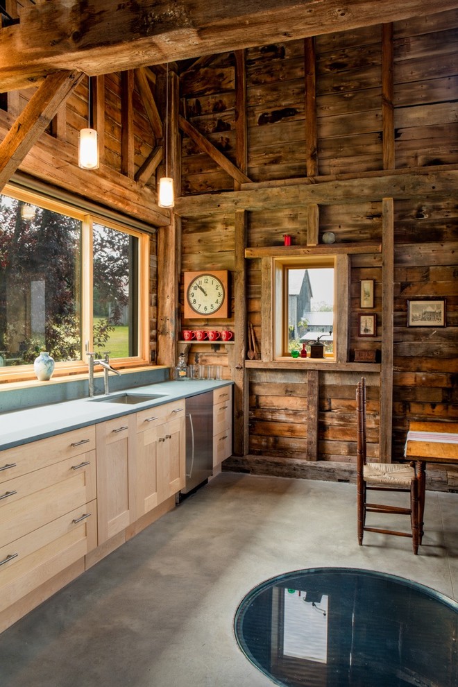 Immagine di una cucina stile rurale con lavello sottopiano, ante in stile shaker, ante in legno chiaro, elettrodomestici in acciaio inossidabile, pavimento in cemento e nessuna isola