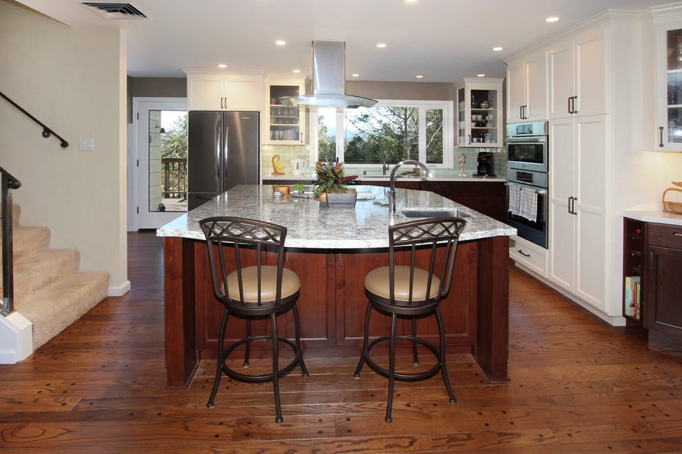 This is an example of a large traditional kitchen/diner in Other with a submerged sink, shaker cabinets, dark wood cabinets, engineered stone countertops, green splashback, porcelain splashback, stainless steel appliances, dark hardwood flooring and an island.