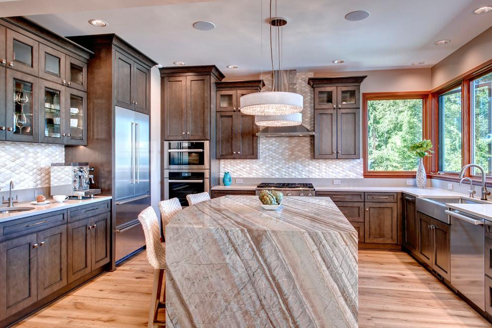 Mid-sized transitional u-shaped light wood floor open concept kitchen photo in Seattle with a farmhouse sink, shaker cabinets, dark wood cabinets, quartzite countertops, beige backsplash, mosaic tile backsplash, stainless steel appliances and an island
