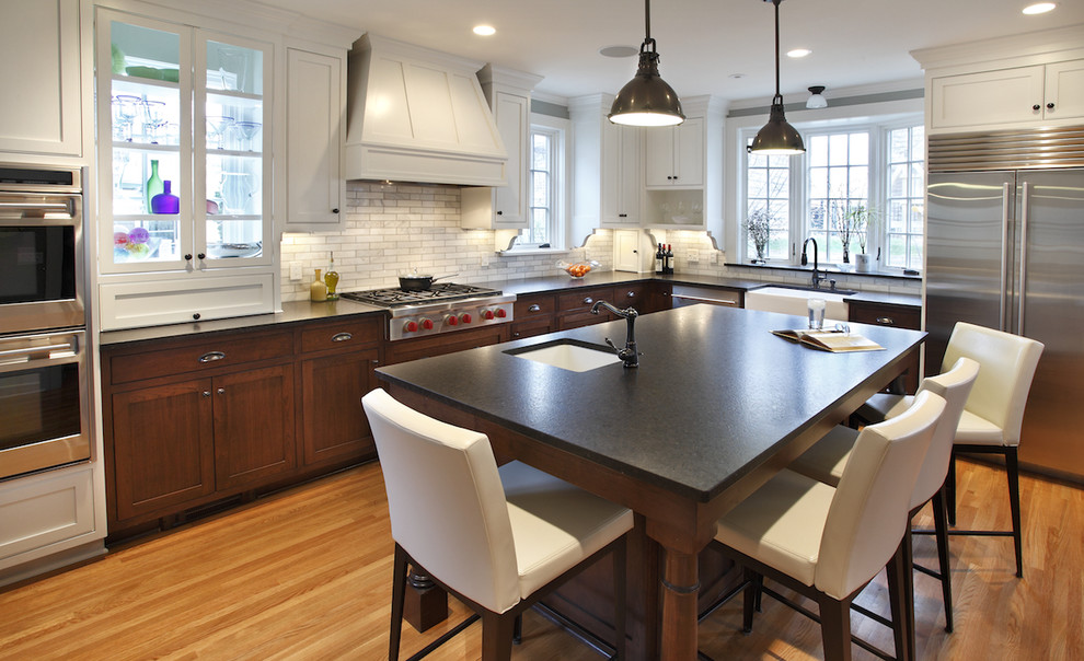Exempel på ett stort modernt kök, med skåp i shakerstil, rostfria vitvaror, granitbänkskiva, en köksö, skåp i mellenmörkt trä, grått stänkskydd, en rustik diskho och ljust trägolv