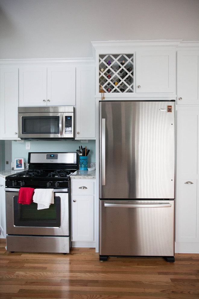 Exempel på ett mellanstort lantligt kök, med en dubbel diskho, skåp i shakerstil, vita skåp, marmorbänkskiva, vitt stänkskydd, stänkskydd i sten, rostfria vitvaror och mellanmörkt trägolv