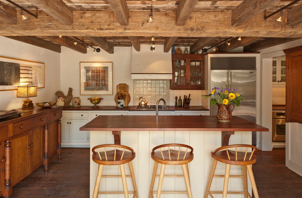 Klassische Küche mit profilierten Schrankfronten, weißen Schränken, Arbeitsplatte aus Holz, Küchenrückwand in Weiß und Küchengeräten aus Edelstahl in Philadelphia